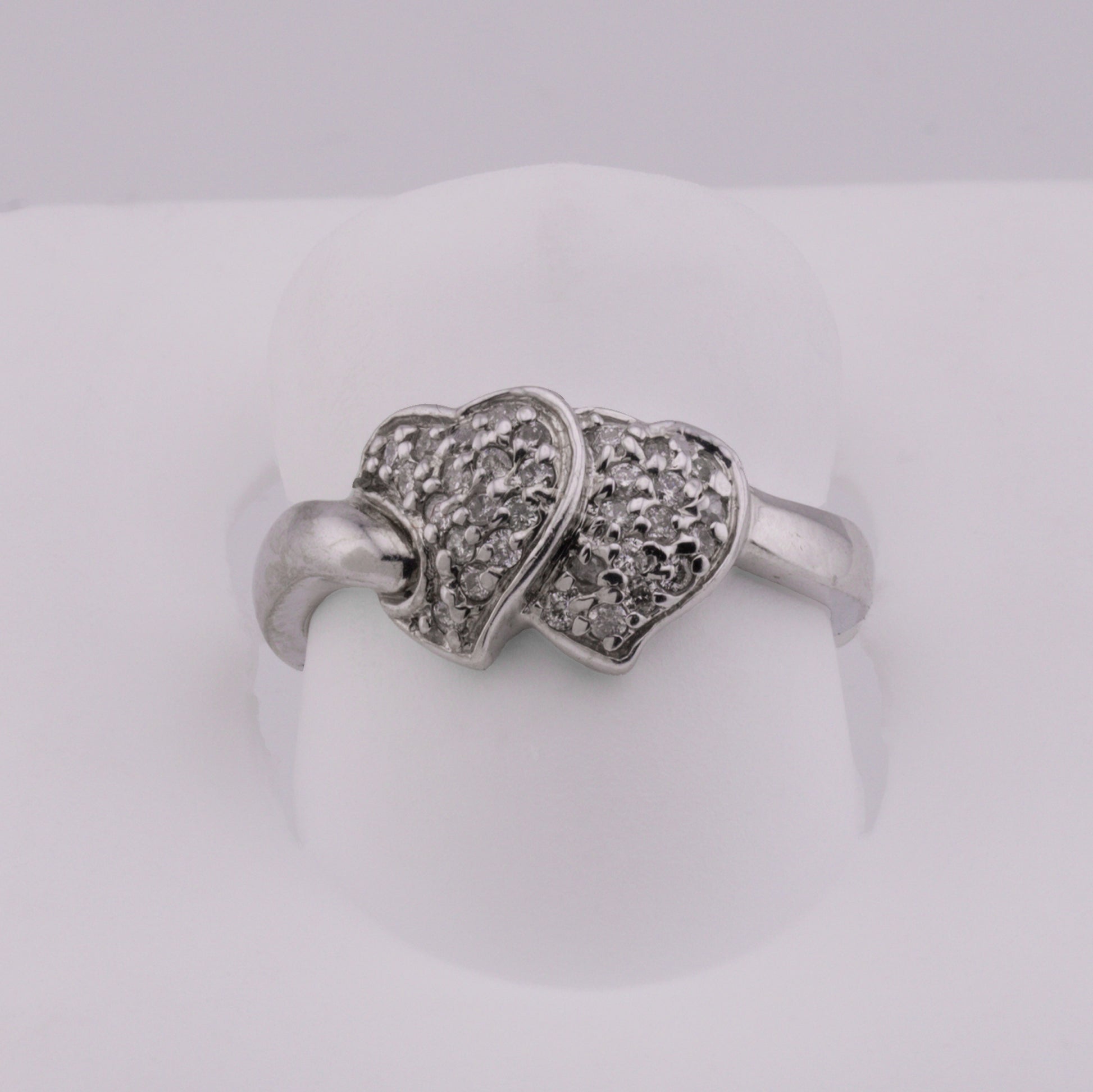 Silver ring with heart design on a white background