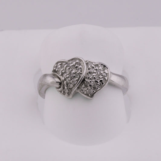 Silver ring with heart design on a white background
